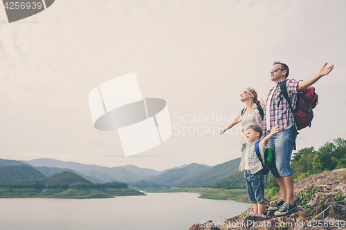 Image of Happy family standing near the lake.