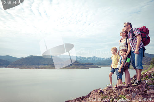 Image of Happy family standing near the lake.