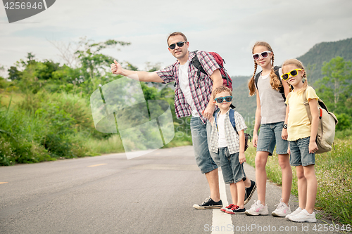 Image of Father and children walking on the road.