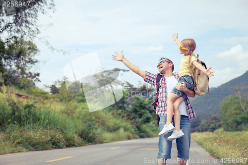 Image of Father and daughter walking on the road.