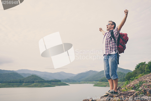 Image of Happy man standing near the lake.