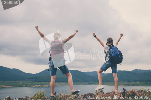 Image of Mother and daughter standing near the lake.