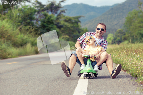 Image of Father and daughter playing on the road.