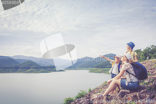 Image of Happy family standing near the lake.