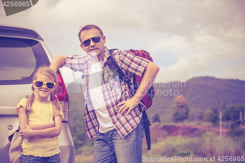 Image of Father and daughter walking on the road.