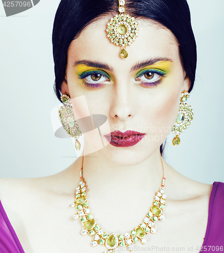 Image of young pretty caucasian woman like indian in ethnic jewelry close up on white, bridal bright makeup fashion people