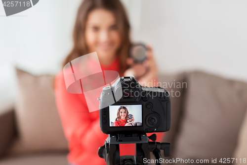 Image of woman with bronzer and camera recording video