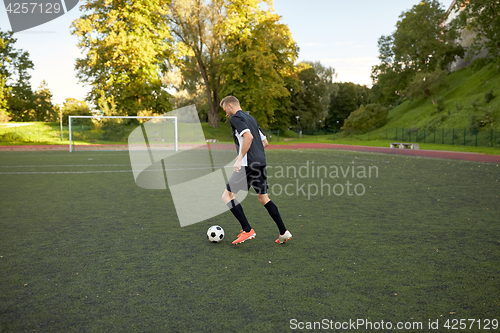 Image of soccer player playing with ball on football field