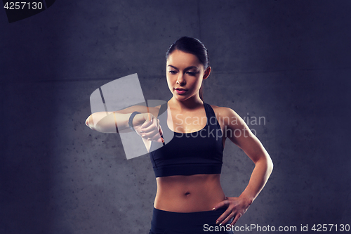 Image of young woman with heart-rate watch in gym