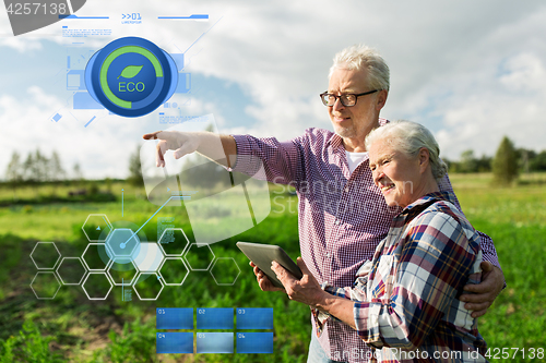 Image of happy senior couple with tablet pc at summer farm