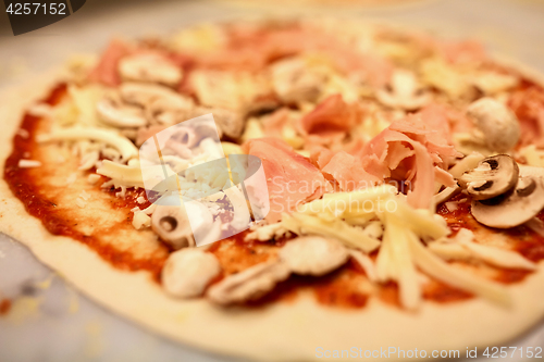 Image of close up of pizza with cheese, ham and champignons