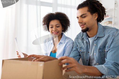 Image of happy couple with parcel box and paper form home