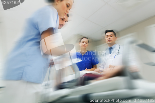 Image of medics and patient on hospital gurney at emergency