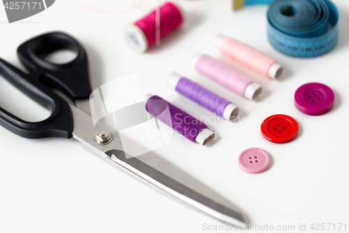 Image of scissors, sewing buttons, threads and tape measure