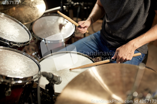 Image of male musician playing drums and cymbals at concert