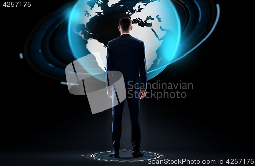 Image of businessman with earth globe hologram over black