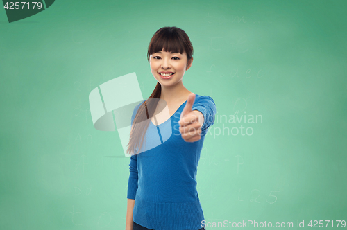 Image of happy smiling young woman showing thumbs up