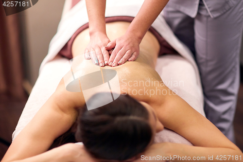 Image of woman having back massage with gel at spa