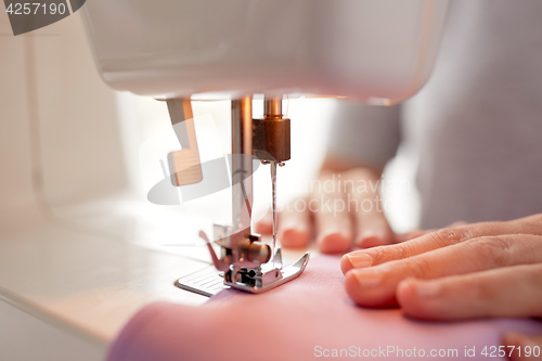 Image of sewing machine presser foot stitching fabric