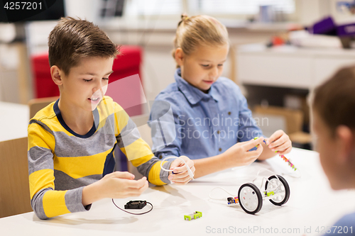 Image of happy children building robots at robotics school