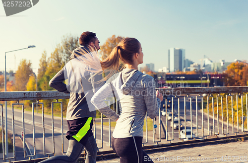 Image of happy couple running outdoors