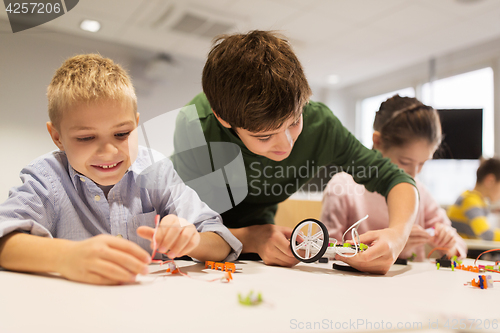 Image of happy children building robots at robotics school