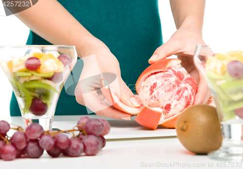 Image of Cook is peeling grapefruit for fruit dessert