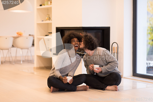 Image of multiethnic couple  in front of fireplace