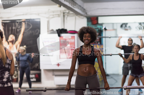 Image of black woman lifting empty bar