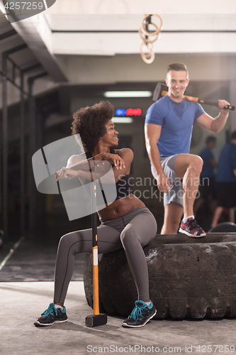 Image of multiethnic couple after workout with hammer