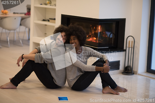 Image of multiethnic couple with tablet computer on the floor