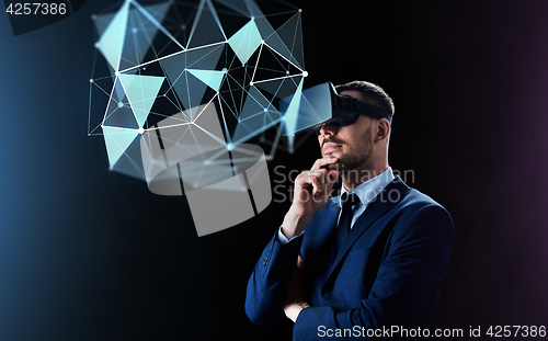 Image of businessman in virtual reality headset over black