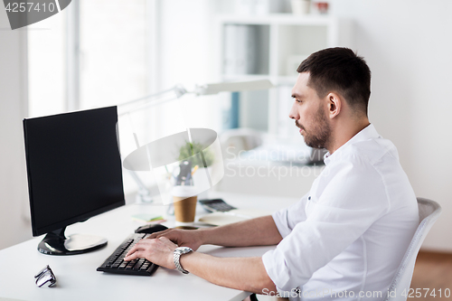 Image of businessman typing on computer keyboard at office