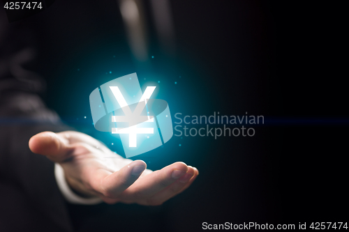 Image of Businessperson hand holding yen symbol