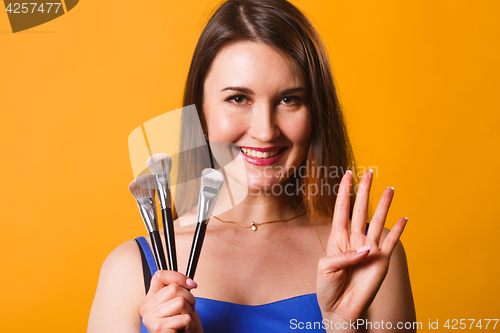 Image of Smiling girl with make-up brushes