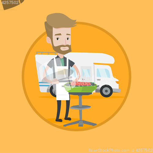 Image of Man having barbecue in front of camper van.