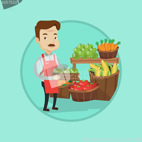 Image of Supermarket worker with box full of apples.