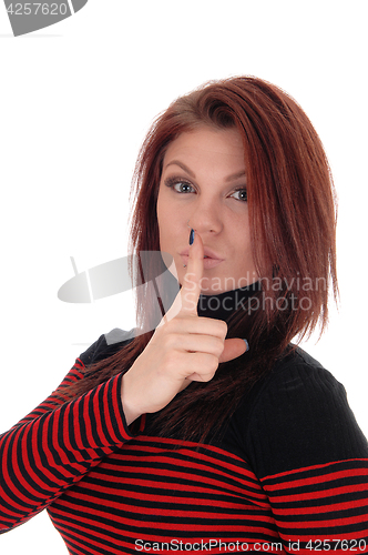 Image of Young woman with finger over mouths.