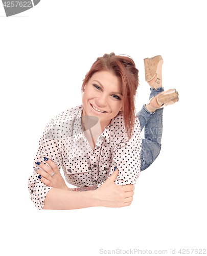 Image of Smiling young woman lying on floor.