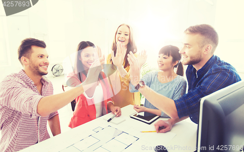 Image of creative team making high five at office