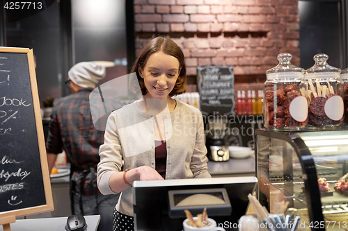 Image of happy woman or barmaid with cashbox at cafe