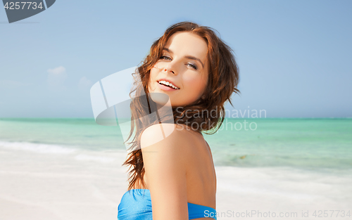 Image of happy woman in bikini swimsuit on tropical beach