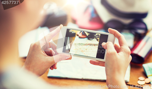 Image of close up of woman with smartphone and travel stuff