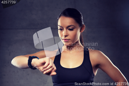 Image of young woman with heart-rate watch in gym