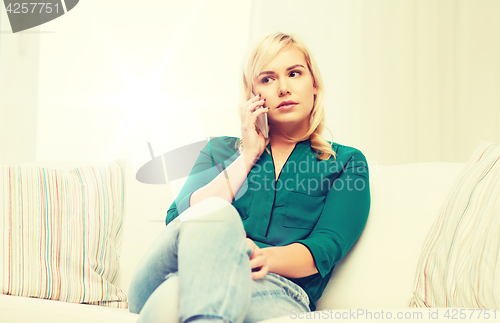 Image of young woman calling on smartphone at home