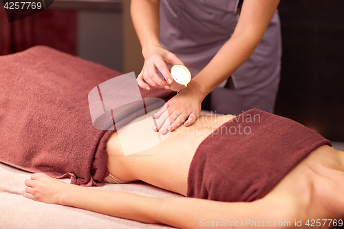 Image of woman lying and having massage with hot oil at spa