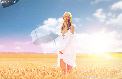 Image of smiling young woman in white dress on cereal field