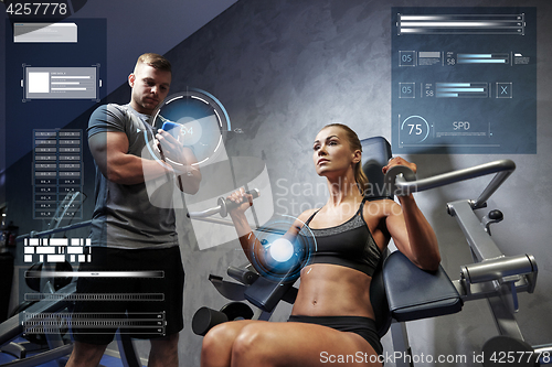 Image of man and woman flexing muscles on gym machine