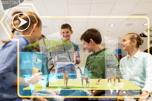 Image of group of happy children with tablet pc at school