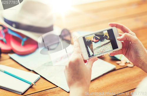 Image of close up of woman with smartphone and travel stuff